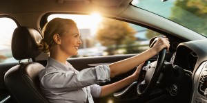 Photo of a beautiful smiling young businesswoman driving car